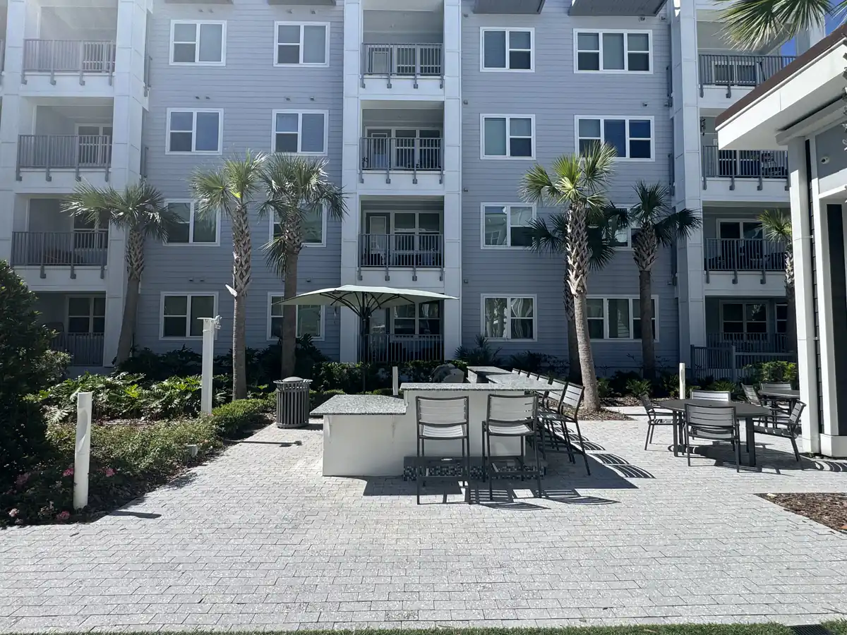 Sanford apartment courtyard before with an open paver patio and grilling island